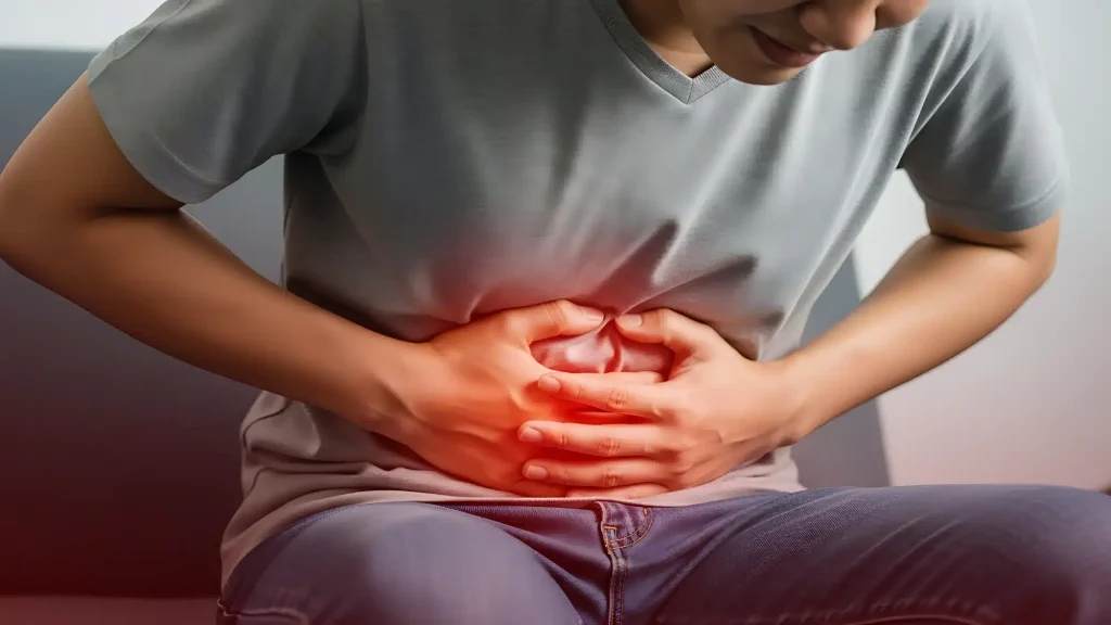Close-up of a person holding their stomach to represent ongoing abdominal pain symptoms requiring a gastroenterologist evaluation.